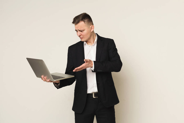 Pettynyt valkoihoinen liikemies kannettavan tietokoneen avulla
 - Valokuva, kuva