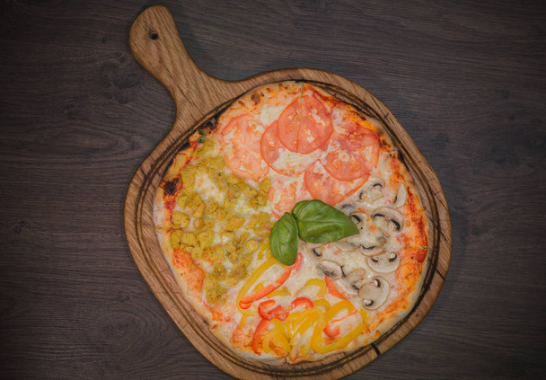 Forró darab pizza egy rusztikus, fából készült asztal olvasztott sajttal - Fotó, kép