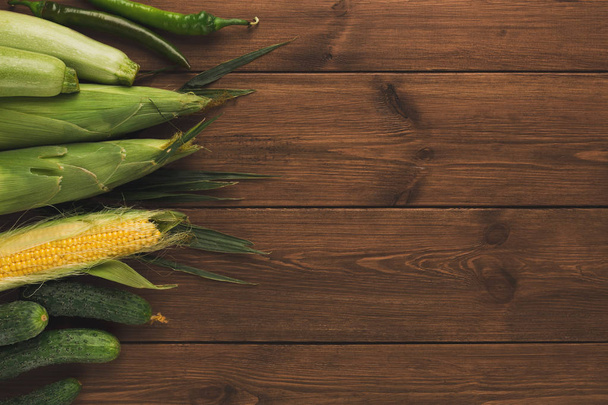 Border of fresh vegetables on wooden background - Фото, изображение