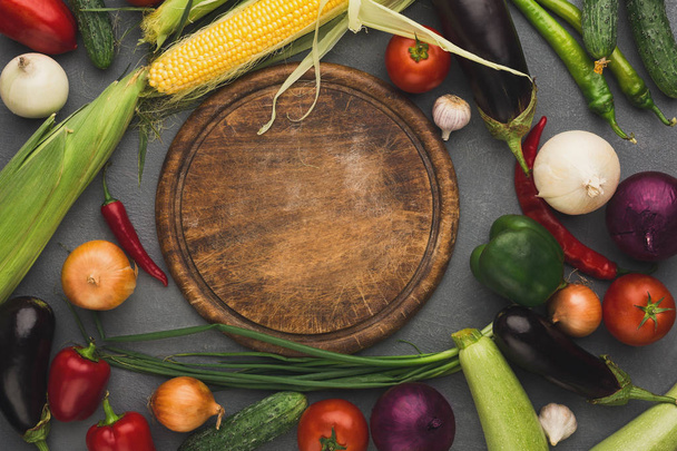 Fresh organic vegetables and wooden board background - Photo, image