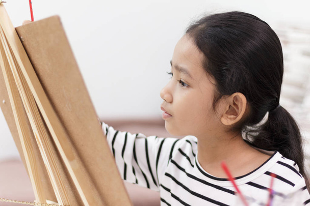 dívka ruka držící červená štětec kreslí obrázek doma - Fotografie, Obrázek