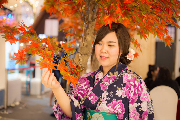 Jovem mulher vestindo kimono tradicional japonês na cor do outono. Japão
 - Foto, Imagem