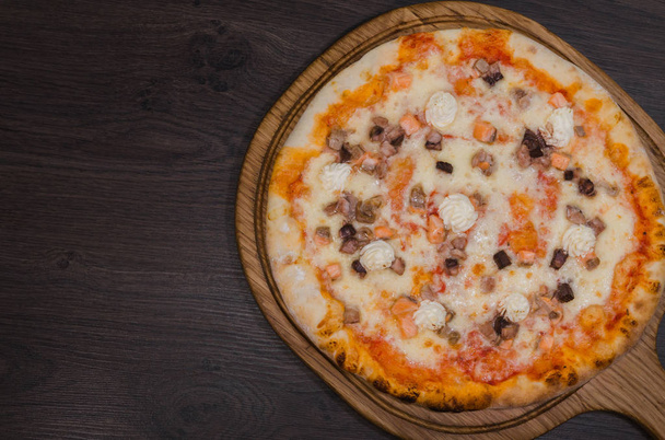 Forró darab pizza egy rusztikus, fából készült asztal olvasztott sajttal - Fotó, kép