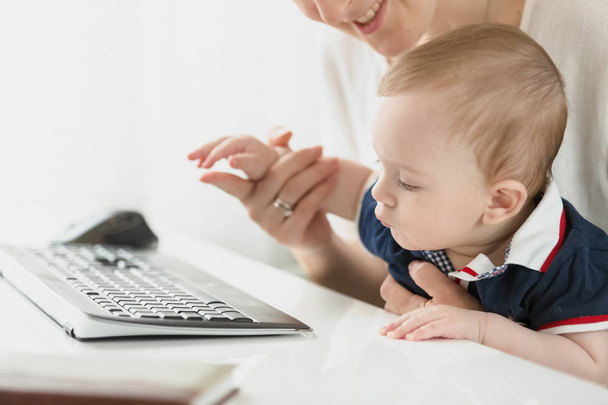 Close-up beeld van baby jongetje kijkt toetsenbord in office - Foto, afbeelding