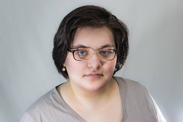 Genç Yetişkin esmer beyaz kadın gözlük ve inci küpe - Fotoğraf, Görsel