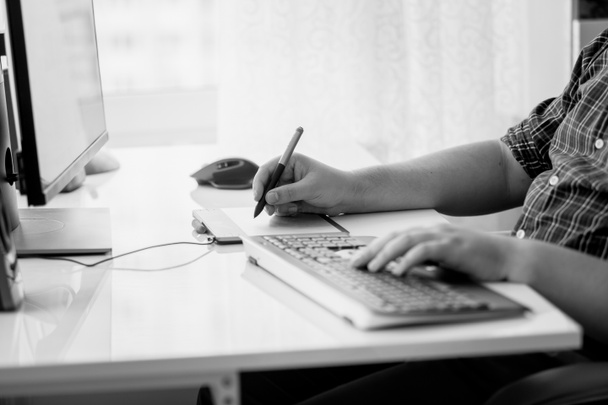 Imagen en blanco y negro del diseñador masculino usando tableta gráfica en la oficina
 - Foto, Imagen