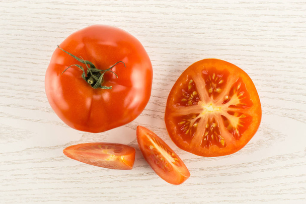 Red tomato collection top view isolated on grey wood background one whole one section half and two slice - Foto, afbeelding