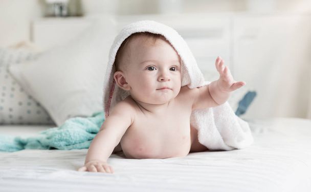 Muotokuva ihana vauva poika pyyhe päällä makaa sängyllä makuuhuoneessa
 - Valokuva, kuva
