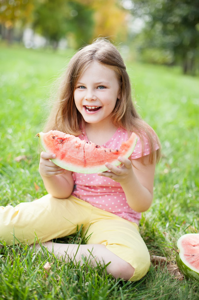 kislány zöld füvet eszik görögdinnye - Fotó, kép