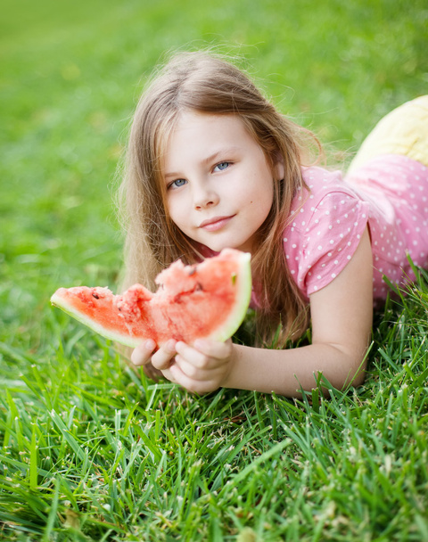 dziewczynka na zielonej trawie jedzenie arbuza - Zdjęcie, obraz
