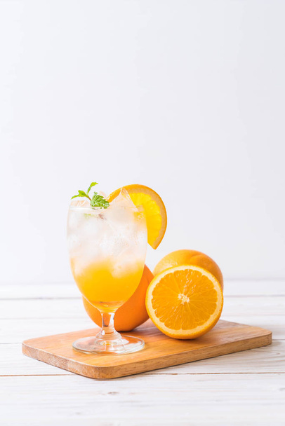orange juice with soda on wood table - Photo, Image