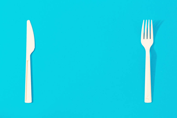 Tasainen lay veitsi ja haarukka sinisellä pohjalla. Top view minimalistinen ruoka tausta
 - Valokuva, kuva