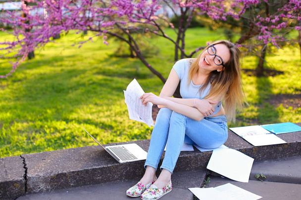Veselá dívka studovat s notebookem a doklady v parku. - Fotografie, Obrázek
