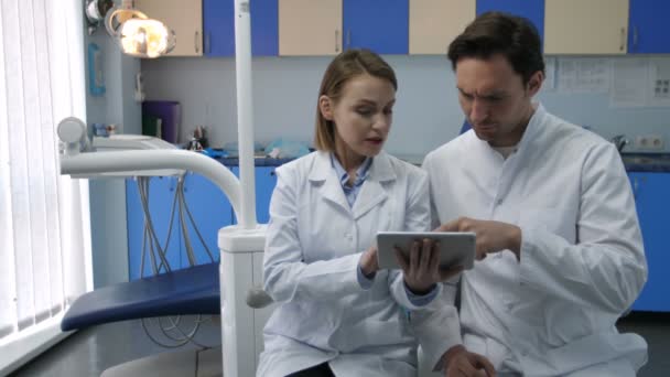 Dentists discussing patients diognosis on tablet - Filmagem, Vídeo