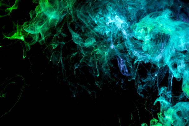 Πυκνό πράσινο και μπλε πολύχρωμα καπνό πάνω σε μαύρο φόντο απομονωμένες.  - Φωτογραφία, εικόνα