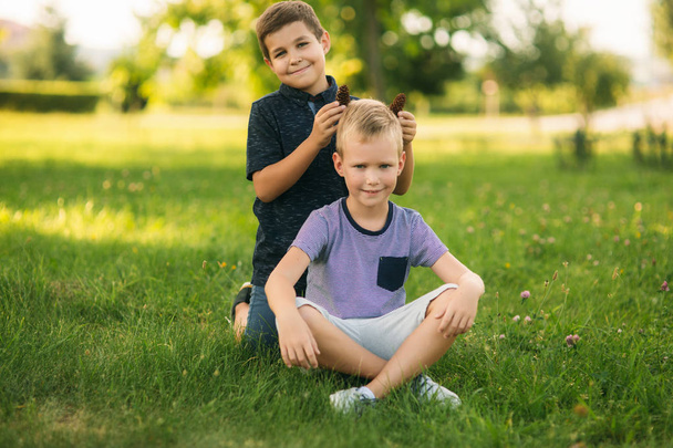 2 人の子供が公園で遊んでいます。T シャツとショート パンツの 2 つの美しい男の子を笑って楽しもう - 写真・画像