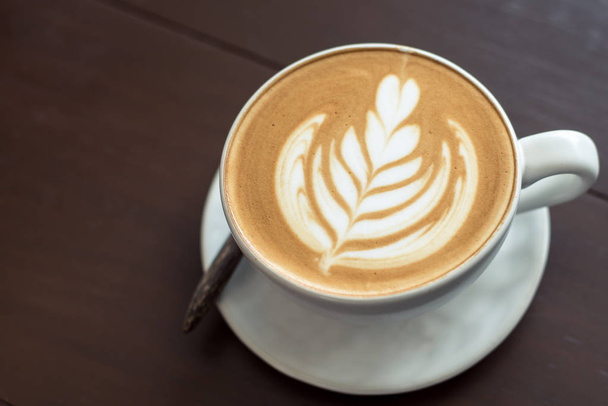 Latte art caffè caldo sul tavolo alla caffetteria
. - Foto, immagini