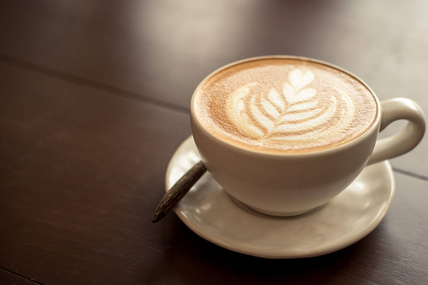 Latte art gorącej kawy na stole w coffee shop. - Zdjęcie, obraz
