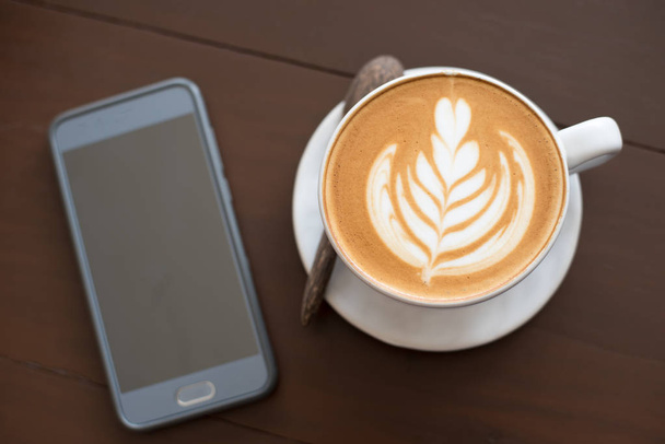 Latte art warme koffie op tafel bij koffie shop. - Foto, afbeelding
