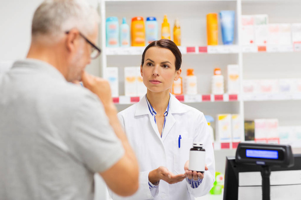 apothecary showing drug to senior man at pharmacy - Fotografie, Obrázek