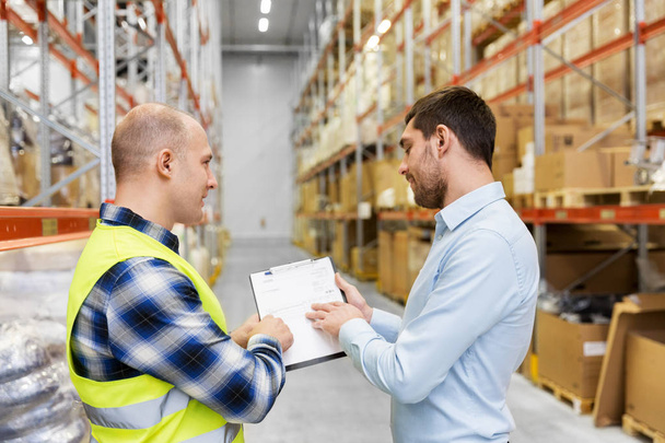 worker and businessman with clipboard at warehouse - Photo, image