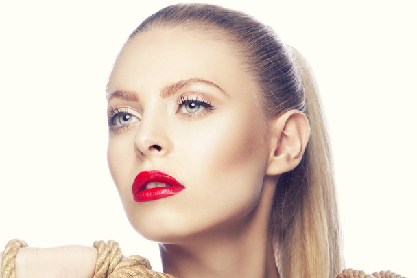 Portrait de femme avec maquillage moderne des lèvres rouges et corde dans les mains
 - Photo, image