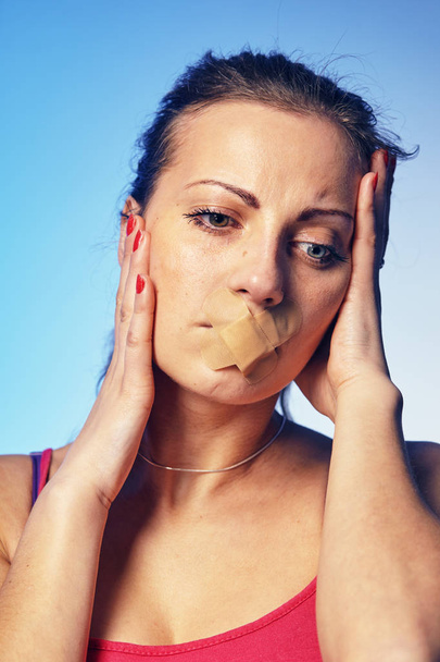 Young woman with his mouth glued with tape.  - Foto, Bild