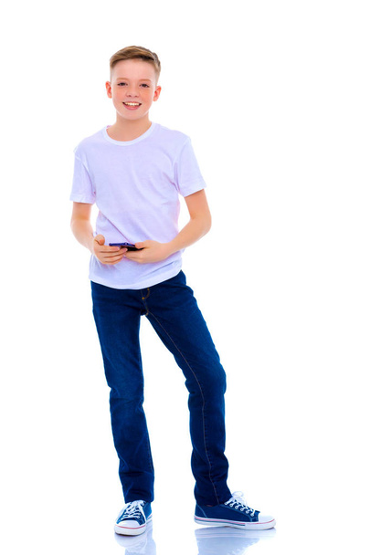 A little boy uses a mobile phone. - Zdjęcie, obraz