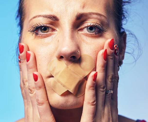 Young woman with his mouth glued with tape. - Fotoğraf, Görsel
