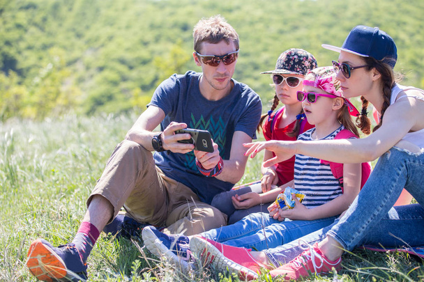Rodina se dvěma dětmi na louce v turistikou v horách - Fotografie, Obrázek