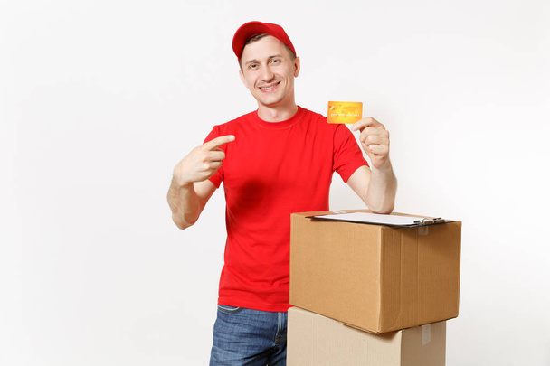 Delivery man in red uniform isolated on white background. Male courier in cap holding credit card, pen, clipboard with papers document, blank empty sheet, cardboard box. Receiving package. Copy space - Photo, Image