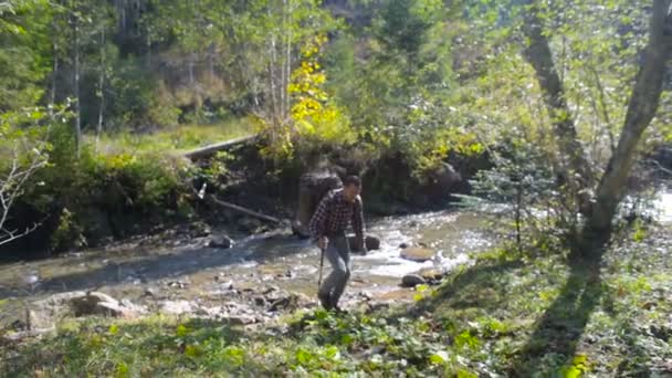hombre con mochila senderismo en las montañas cerca del río
 - Imágenes, Vídeo