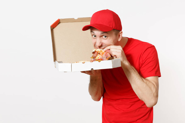 Доставка улыбающийся человек в красной форме изолирован на белом фоне. Мужчина в кепке, футболке, работающий курьером или дилером, держащий итальянскую пиццу в картонной коробке. Копирование места для рекламы
 - Фото, изображение