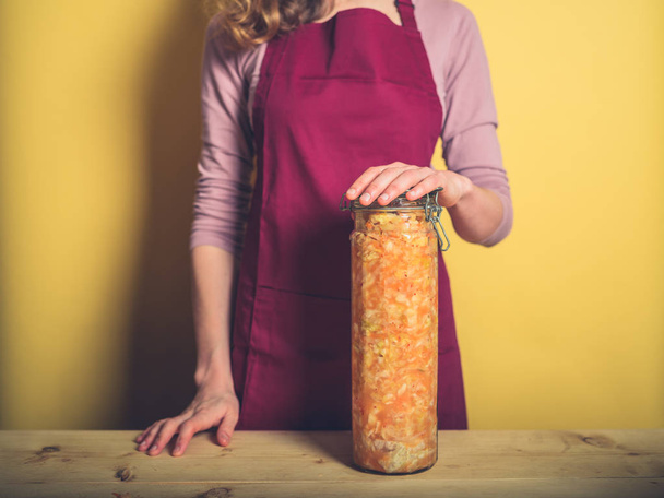 A young woman is holding a massive jar of ultra delicious homemade kimchi - Φωτογραφία, εικόνα