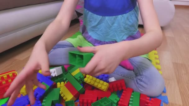 Little girl sorting toy bricks - Materiał filmowy, wideo