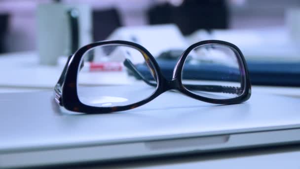 Os óculos estão no laptop na mesa do escritório, close-up
 - Filmagem, Vídeo