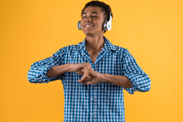 Happy Afro American teenager in headphones dancing - Fotó, kép