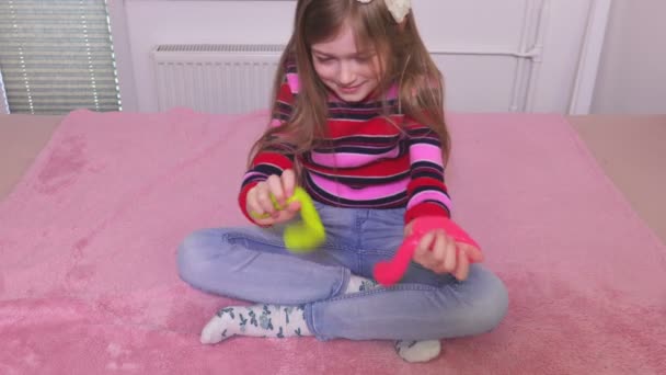 Kleine Mädchen amüsieren sich mit zwei bunten Schleimen - Filmmaterial, Video
