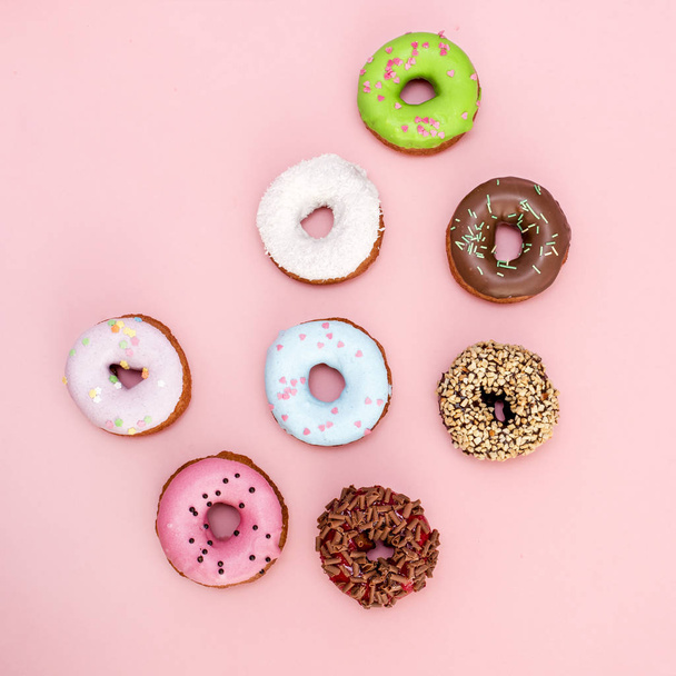 Set of donuts covered with glaze on pink background - 写真・画像