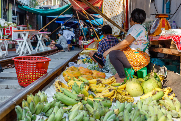 Producenci w słynnym Maeklong railway rynku sprzedaży owoców i warzyw na torach kolejowych, Prowincja Samut Songkhram, Tajlandia - Zdjęcie, obraz