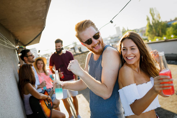 Happy young attractive couple having fun time at party - Photo, Image