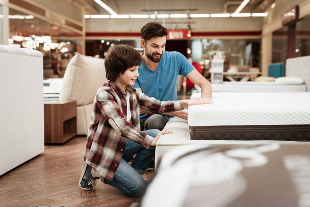father with son choosing orthopedic mattress in furniture store - Photo, Image