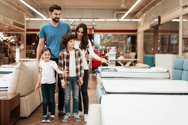 family choosing and buying new orthopedic mattress in furniture store - Fotó, kép