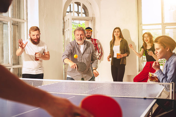 Groupe de jeunes amis heureux jouant au ping pong tennis de table
 - Photo, image