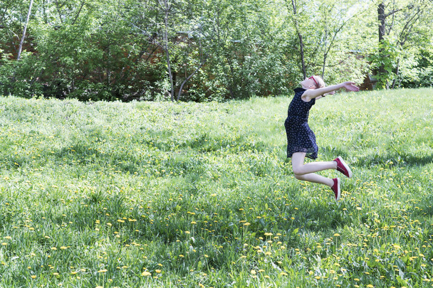 Girl jumping among dandelions - Foto, afbeelding