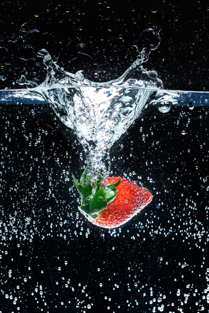 close up view of fresh strawberry in water isolated on black - Photo, image
