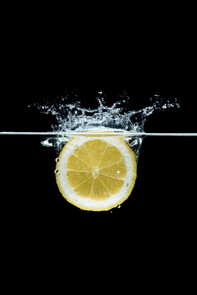 vista de perto de pedaço de limão na água isolada em preto
 - Foto, Imagem