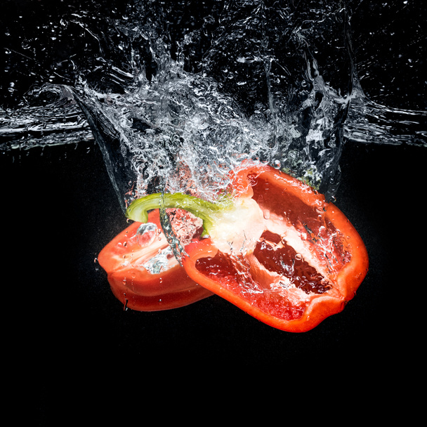 close up view of bell pepper pieces in water isolated on black - Foto, Imagen