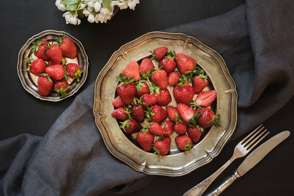 Fresh organic strawberry in vintage plate on black table. Spring. Top view. - Foto, Imagen
