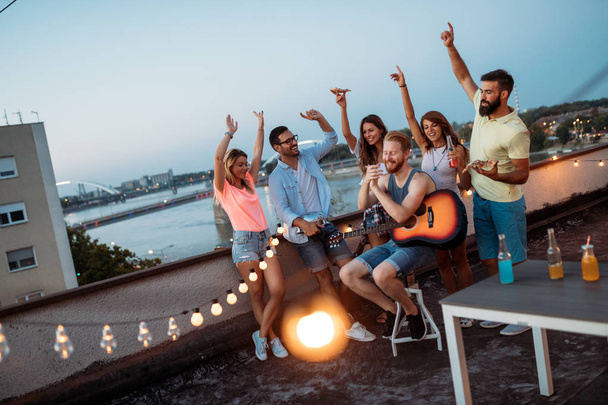 Group of happy young friends having party on rooftop - Photo, image